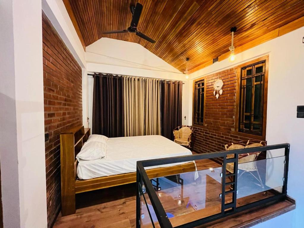 a bedroom with a bed and a glass balcony at Neems paradise in Point Pedro