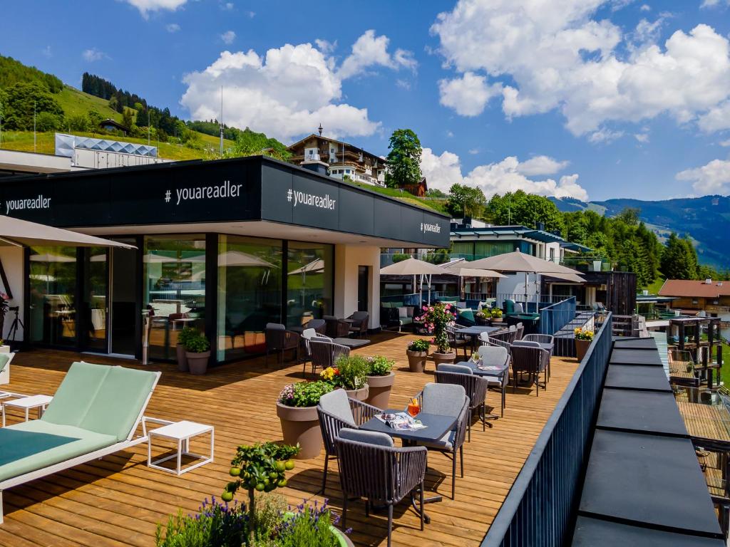 taras z krzesłami i stołami w budynku w obiekcie Adler Resort w Saalbach Hinterglemm