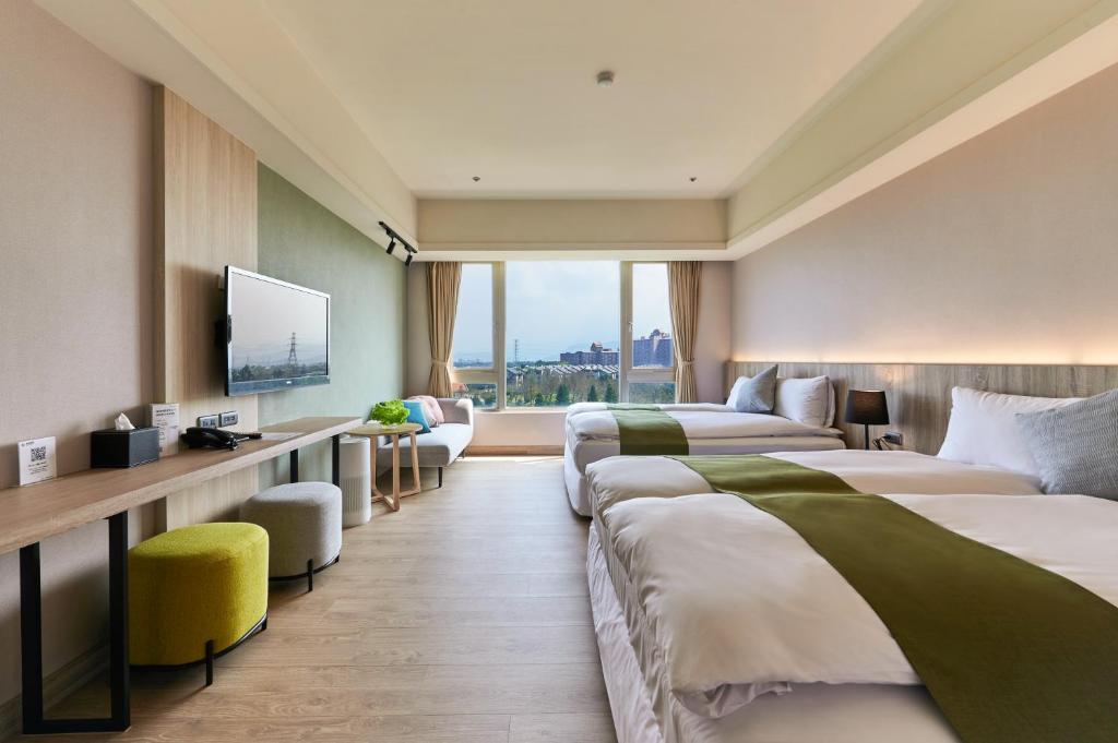 una camera d'albergo con due letti e una televisione di Aspire Resort a Longtan
