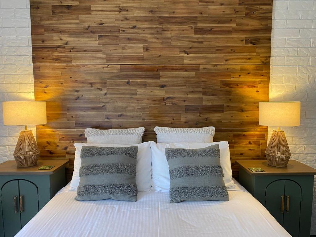 a bedroom with a bed with two lamps on two tables at Beachmere Palms Motel in Beachmere