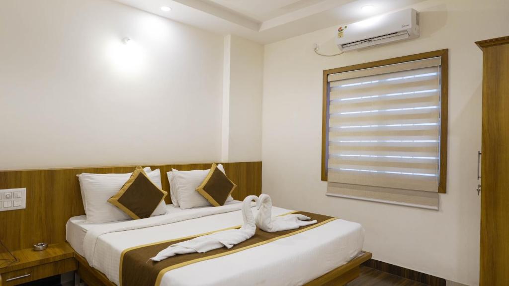 2 łóżka w pokoju hotelowym z ręcznikami w obiekcie Sepoy Elite By Yuvraj Group of Hotels w mieście Mysuru
