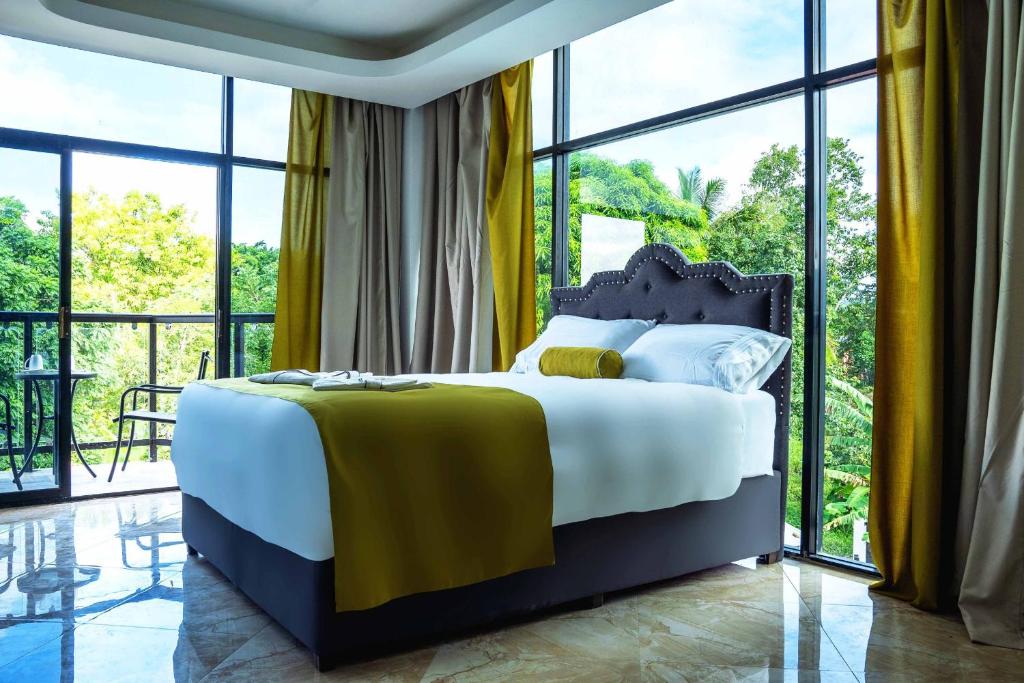 1 dormitorio con 1 cama grande y ventanas grandes en The Alexandria Marquis Hotel and Resort en San Ignacio