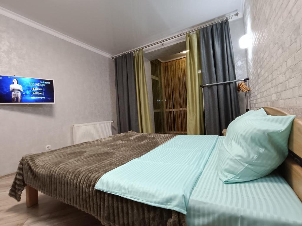 um quarto com uma cama e uma televisão na parede em новобудова ЖК Яровиця, смарт тв em Lutsʼk