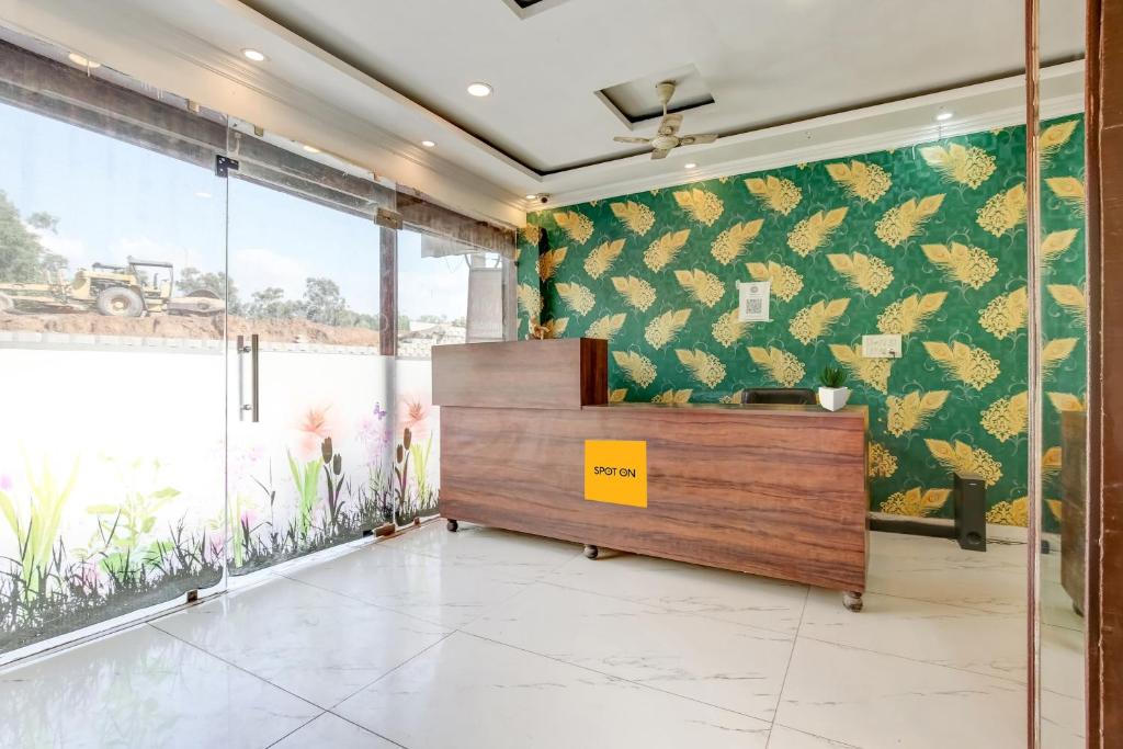 recepción en una habitación con pared de papel de piña en SPOT ON Hotel New Style, en Zirakpur