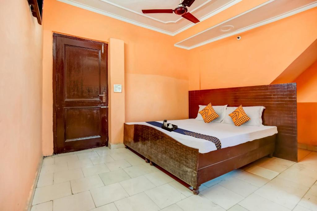 una camera da letto con un letto con pareti arancioni e un soffitto di SPOT ON Hotel New Style a Zirakpur