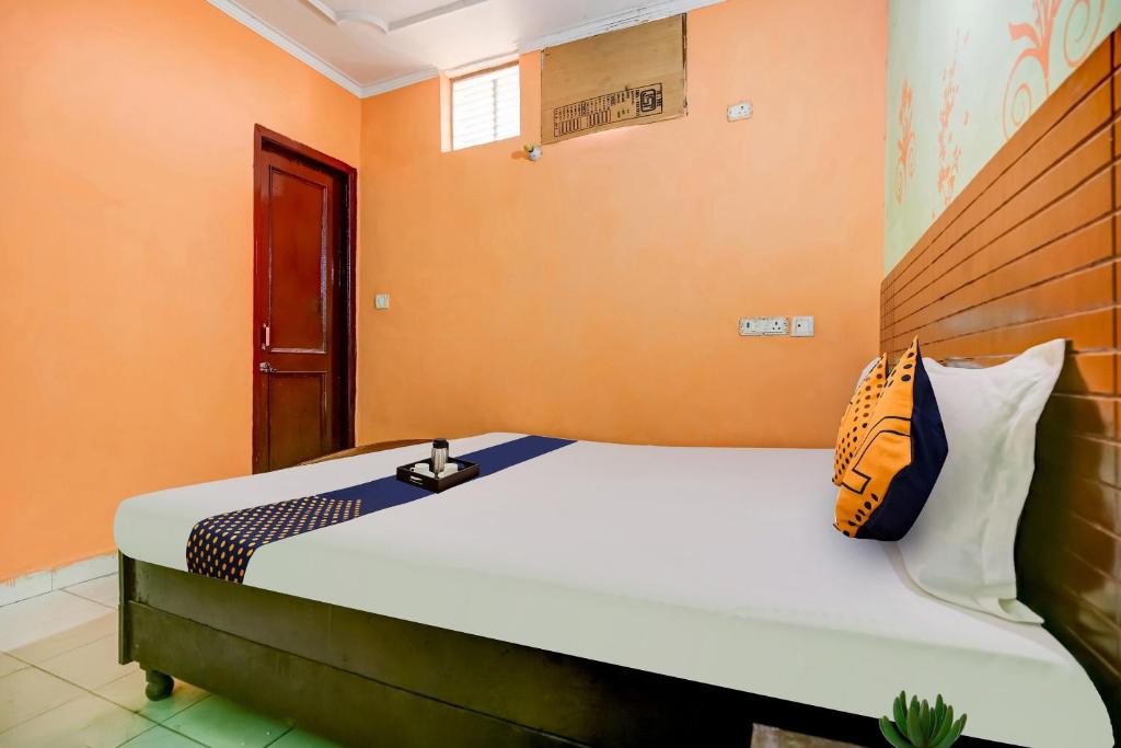 a bedroom with a large bed with orange walls at SPOT ON Hotel New Style in Zirakpur