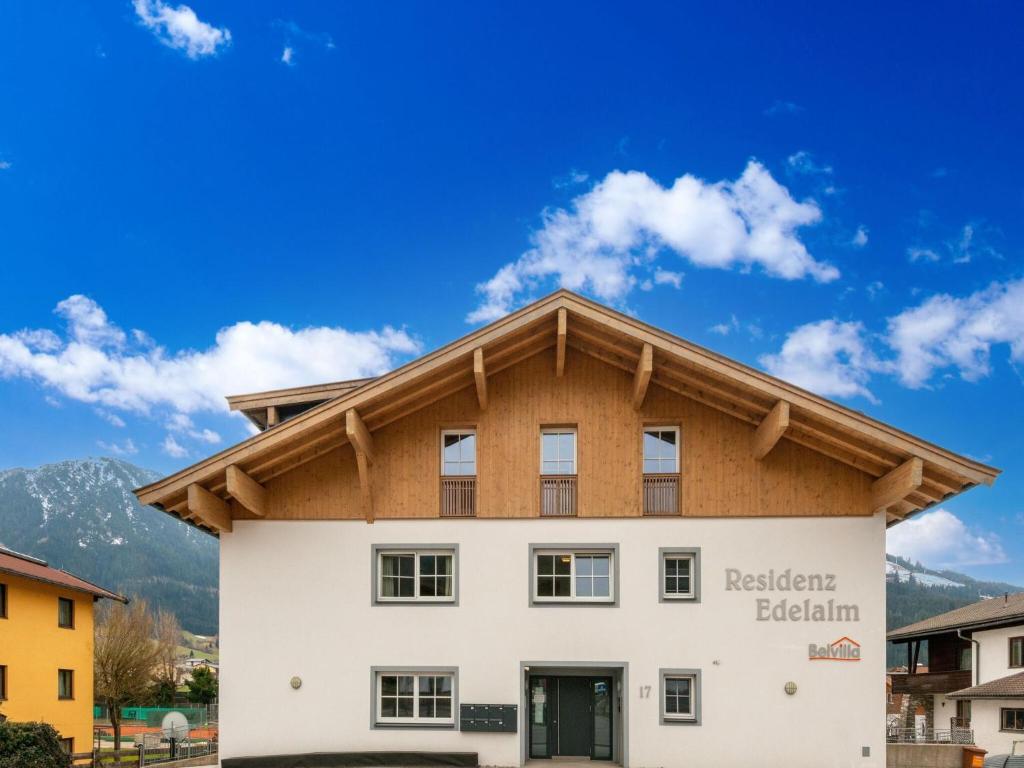 a white building with a wooden roof at Luxury penthouse with Balcony Ski Storage Carport Lift in Brixen im Thale