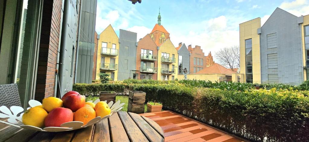 un plato de fruta en una mesa en un balcón en Apartment Neptun Old Town by TriApart en Gdansk