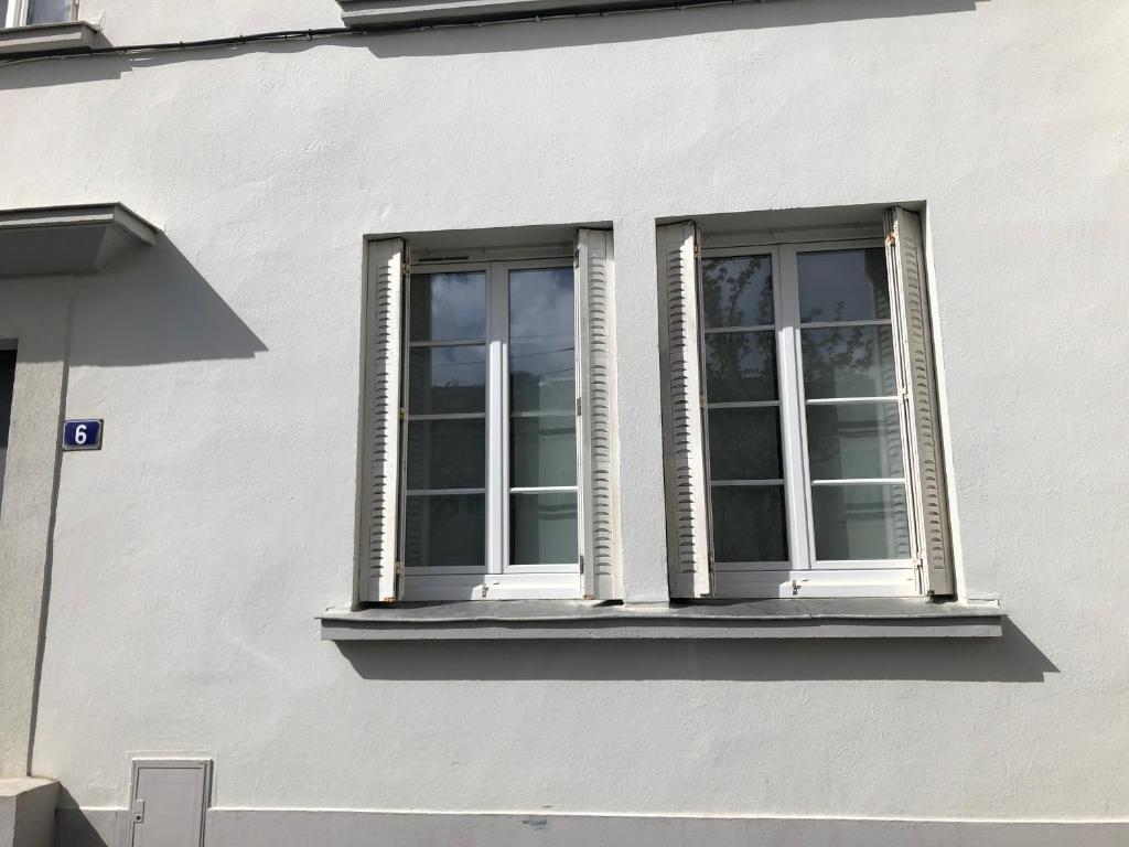 ein Fenster an der Seite eines weißen Gebäudes in der Unterkunft Eden Blue charmant appartement proche centre avec Garage Gratuit in Nantes