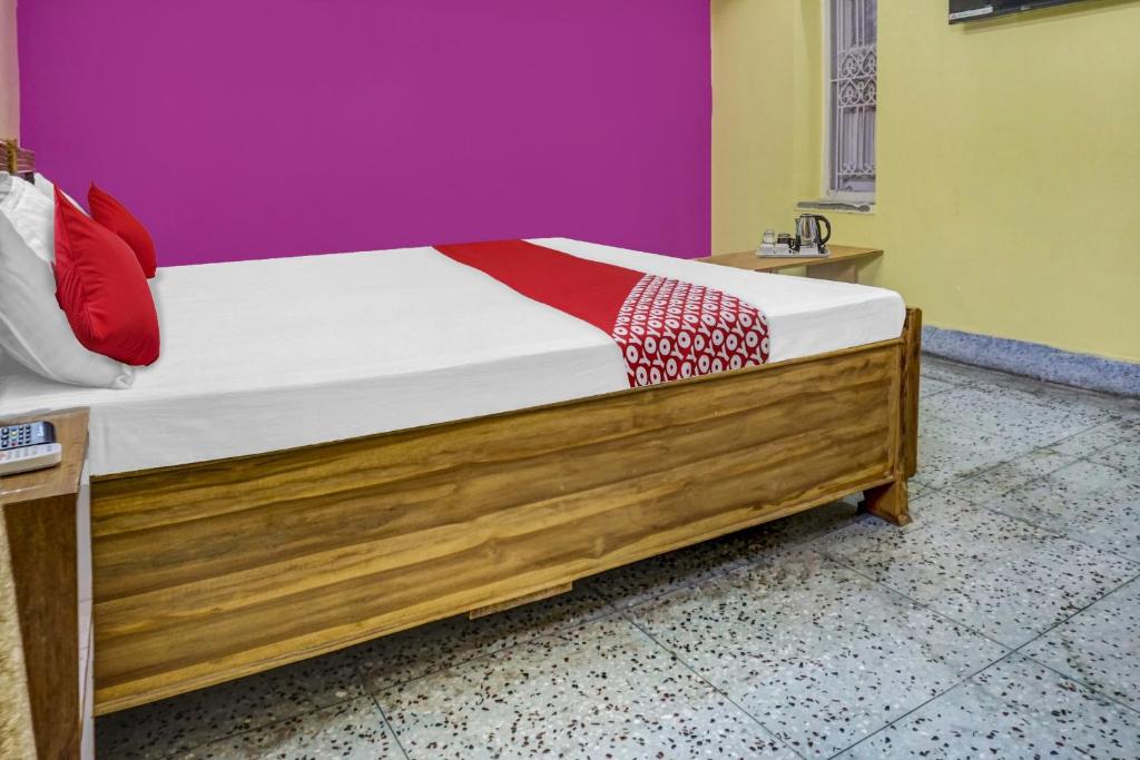 ein Bett mit einem Holzrahmen in einem Zimmer in der Unterkunft OYO Flagship Hotel Kashyap Heritage in Patna