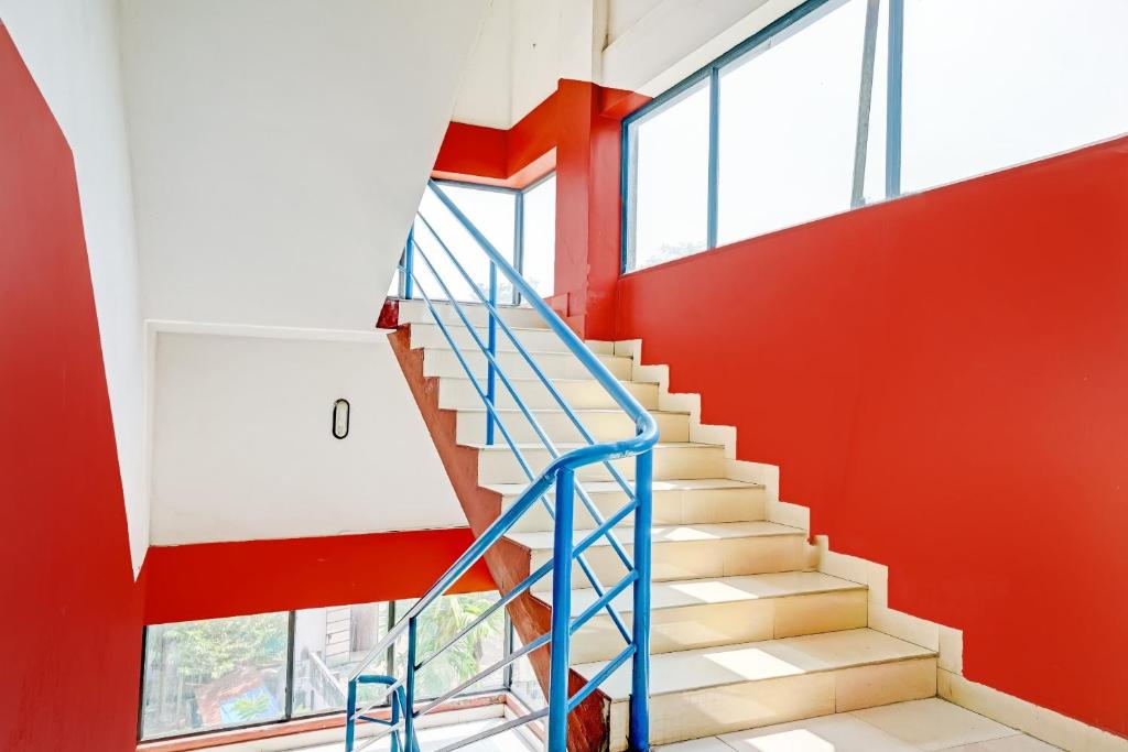 a staircase in a building with a blue railing at SPOT ON Cherai Homes in Cherai Beach