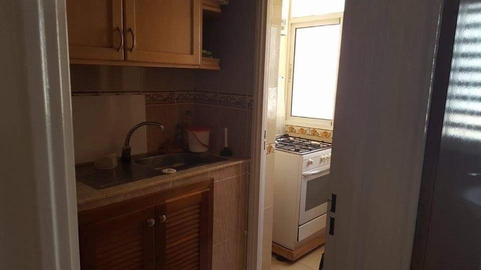 a kitchen with a sink and a stove and a window at Appartement bien meublé à martil in Martil