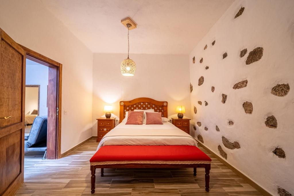 ein Schlafzimmer mit einem Bett und einer Wand mit Steinen in der Unterkunft Casa Francisca in Teguise