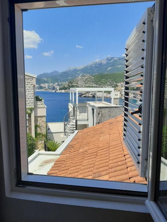 a view of the ocean from a window at Apartments Mitrovići Miločer in Sveti Stefan