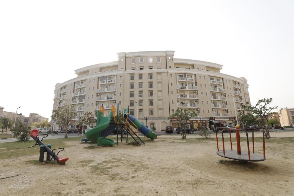 a playground in front of a large building at The Grand View Studio in Vrindāvan