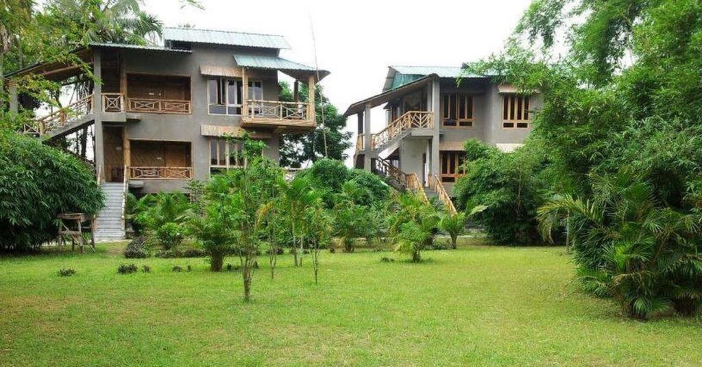 un gran edificio con un patio delante en SDD Bamboo Village Resort en Uttar Simlabari