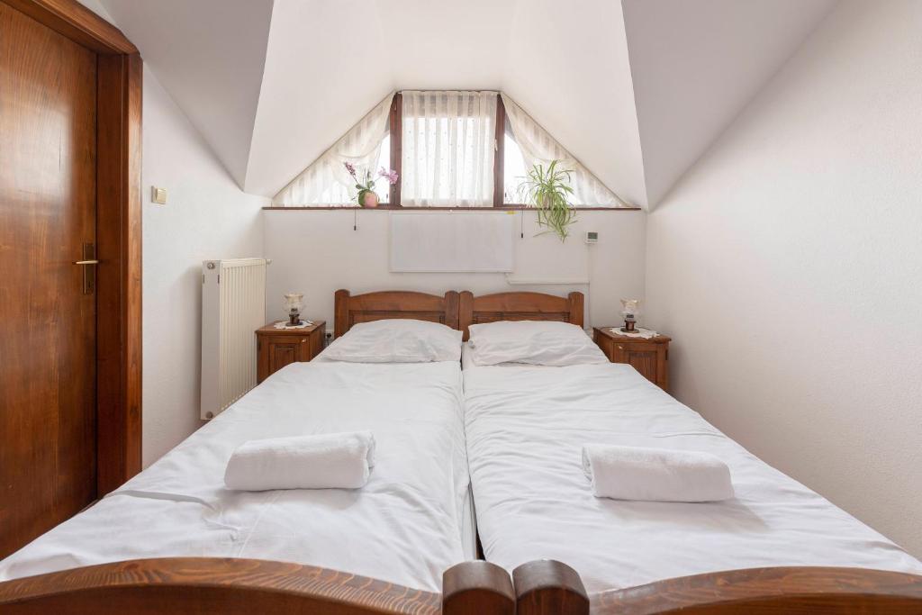 Schlafzimmer mit einem Bett mit weißer Bettwäsche und einem Fenster in der Unterkunft Bed and Breakfast Mili Vrh in Kamnik