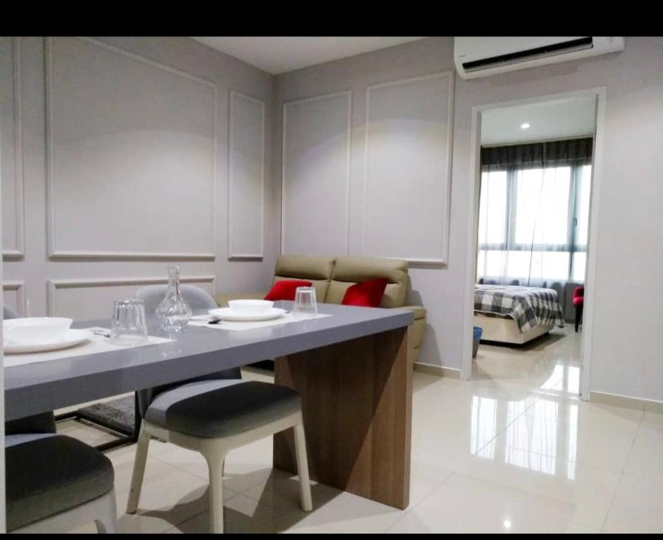 een keuken met een tafel en stoelen en een woonkamer bij I City Suite Free Wifi in Shah Alam