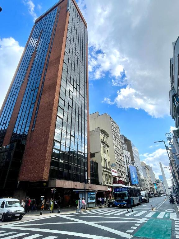 a tall building on a busy city street at Obelisco 818 in Buenos Aires