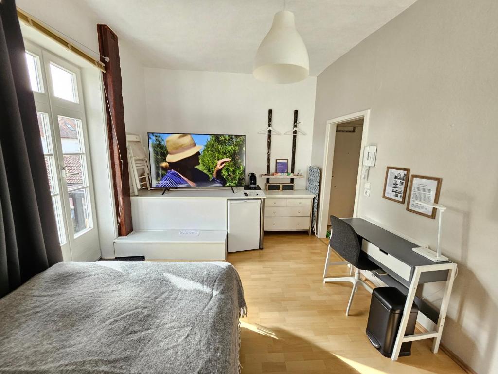 a bedroom with a bed and a kitchen with a piano at Stadtapartment HEF in Bad Hersfeld