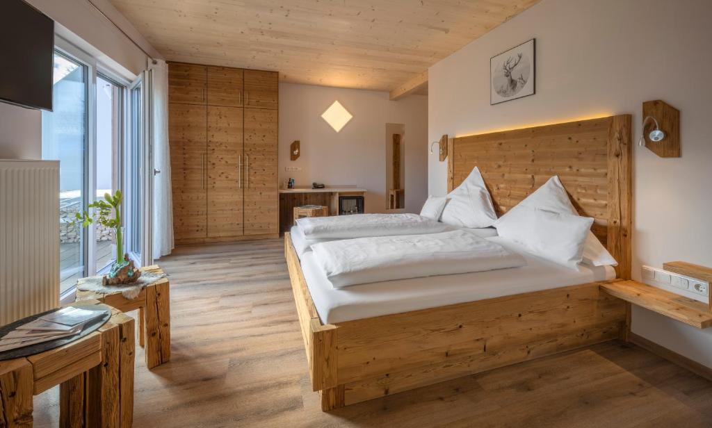 a bedroom with a large bed and a large window at Hotel-Restaurant Gasthaus Bonimeier in Niedergottsau