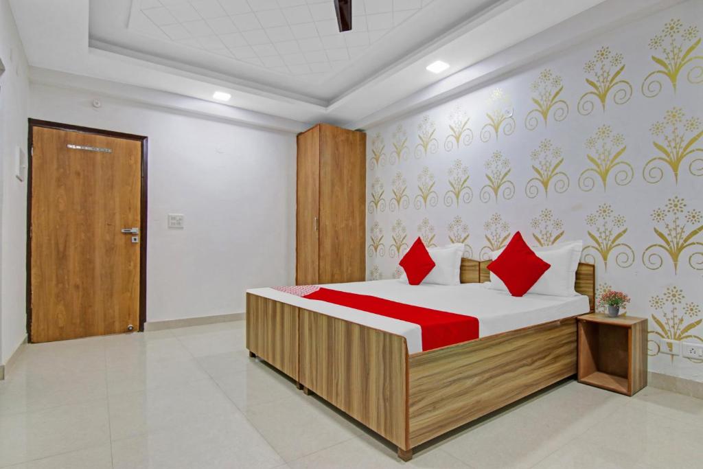a bedroom with a bed with red pillows at Flagship Hotel Check Inn in New Delhi