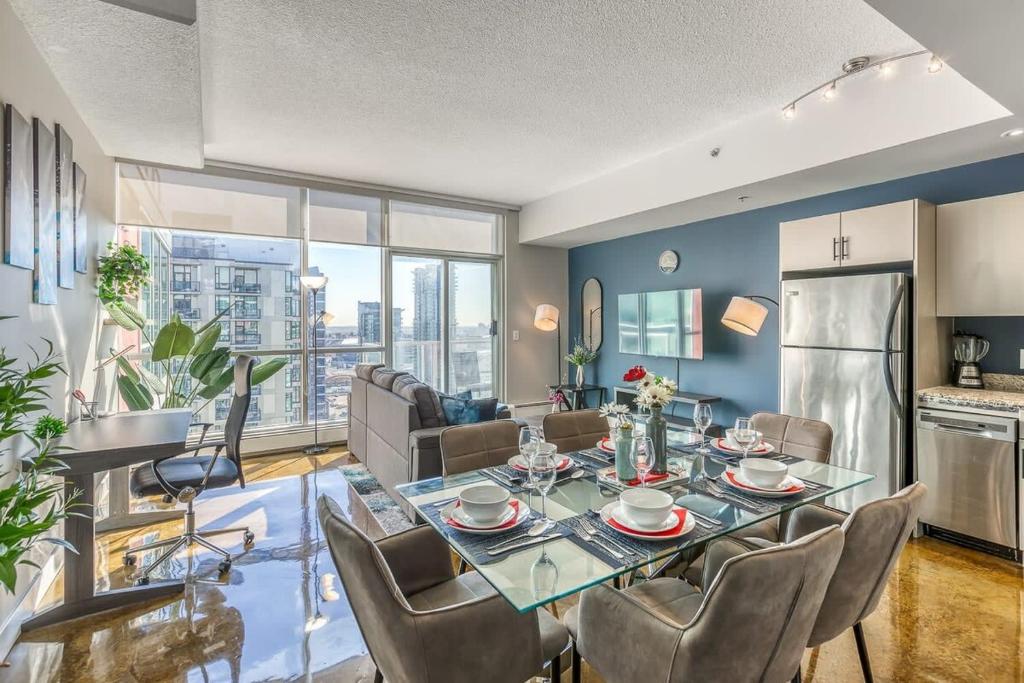 a kitchen and living room with a table and chairs at Cozy 2BR Condo with King Bed and City Views in Calgary