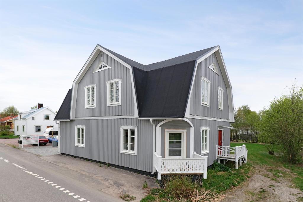 une maison grise avec un toit noir dans une rue dans l'établissement Guestly Homes - 4BR Charming Apartment, à Roknäs