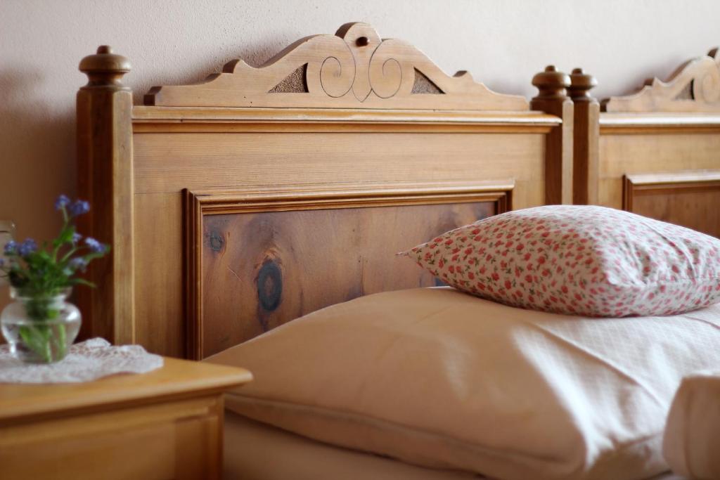 a bed with a wooden headboard and a pillow at Bio Ferienbauernhof Greber in Schwarzenberg