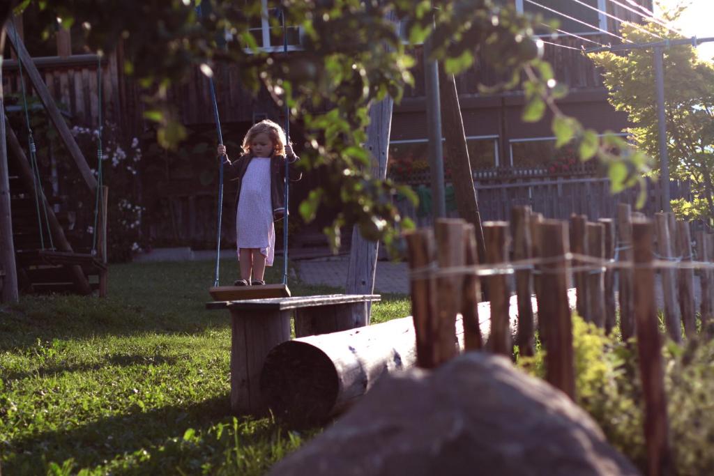 a little girl standing on a swing in a yard at Bio Ferienbauernhof Greber in Schwarzenberg