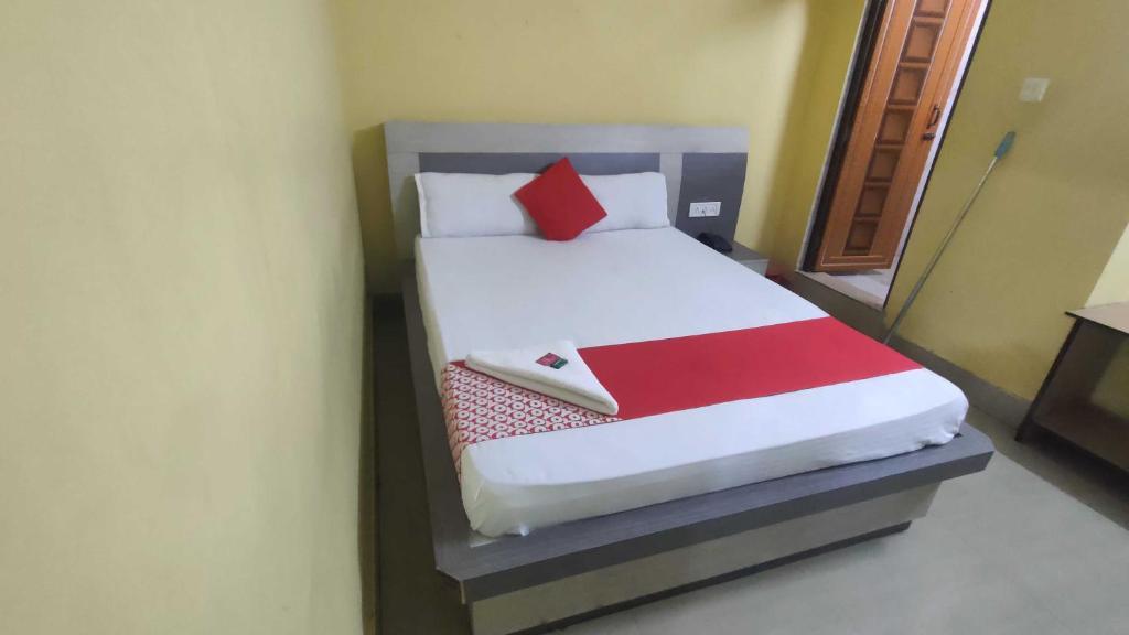 a bedroom with a bed with a red and white blanket at OYO 83046 Hotel Darpan in Nagri