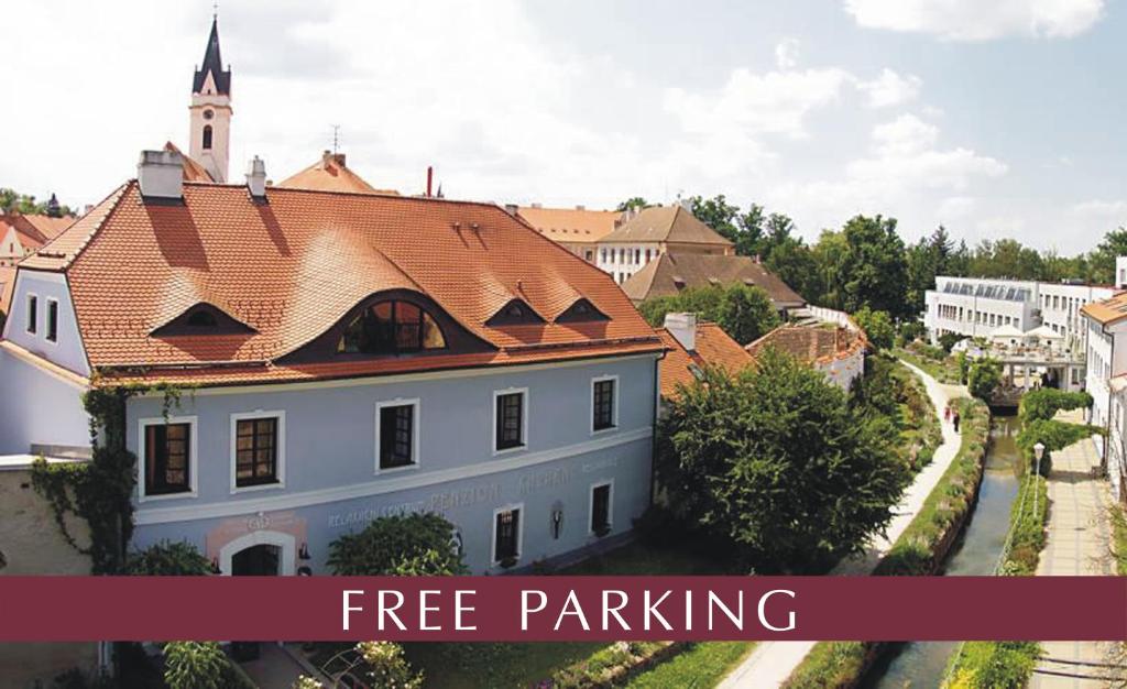 a white building with a red roof with the words free parking at Penzion a restaurace U Míšků in Třeboň