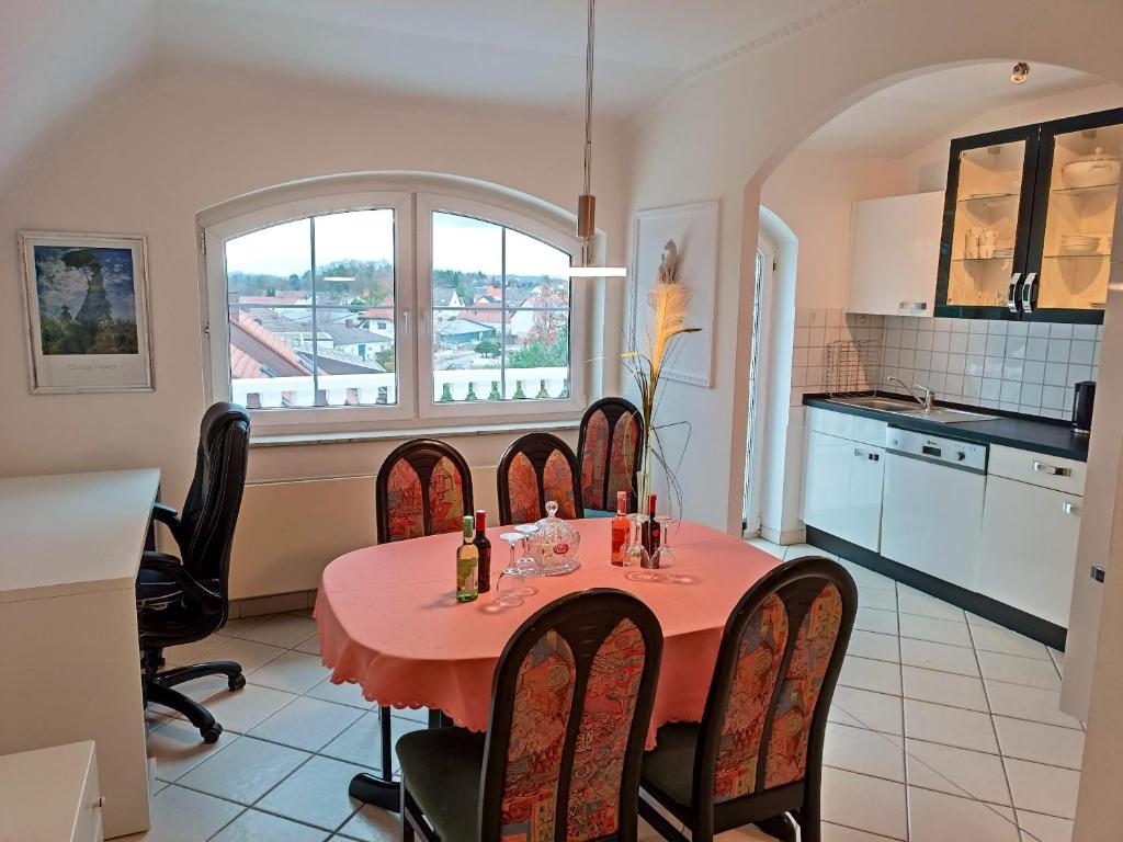 een keuken en eetkamer met een rode tafel en stoelen bij 2 bedrooms apartement with enclosed garden and wifi at Limbach Kirkel in Altstadt