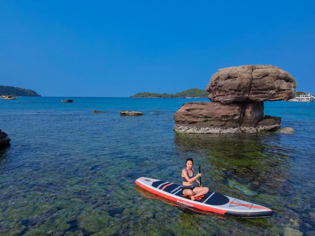 Una donna è seduta su un kayak in acqua di P.H.O Apartment a Phu Quoc