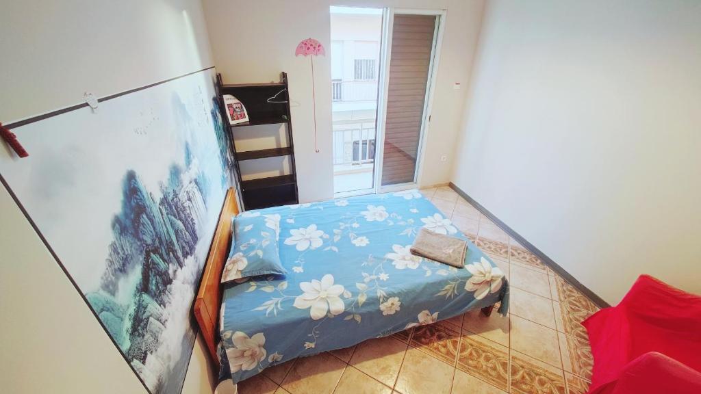Un pequeño dormitorio con una cama azul con flores. en A private room for 1 person（Girl Lady Prioritize) share others with me and my bf en Athens