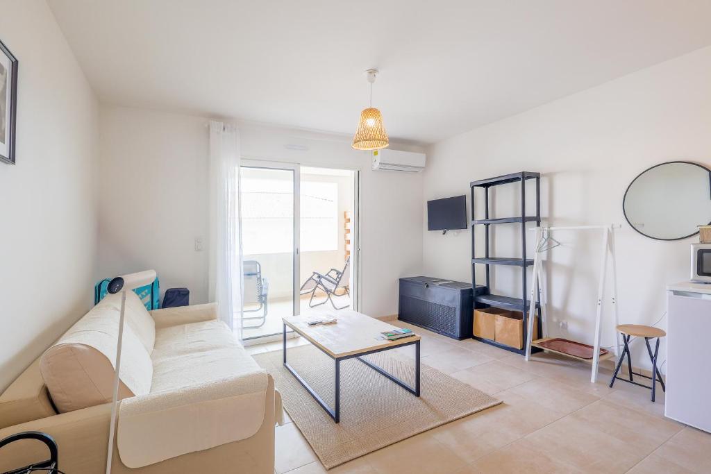 un salon avec un canapé et une table dans l'établissement Linguizzetta - studio climatisé - piscine partagée, à Linguizzetta