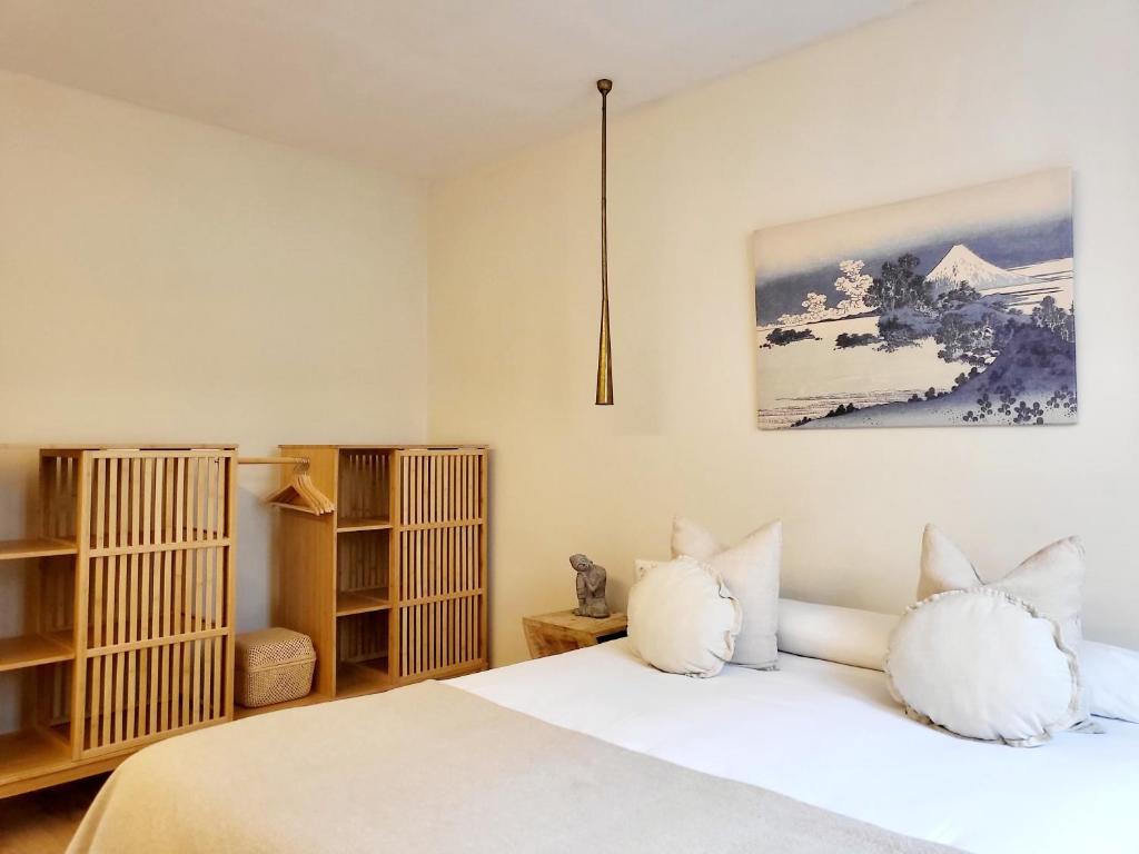 1 dormitorio con cama blanca y almohadas blancas en Celta Home, en Vigo