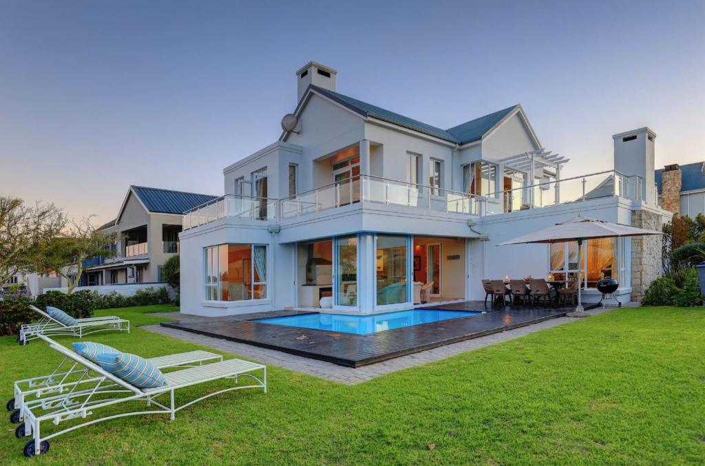 a large white house with a pool in the yard at White House on Kingswood Golf Estate in George