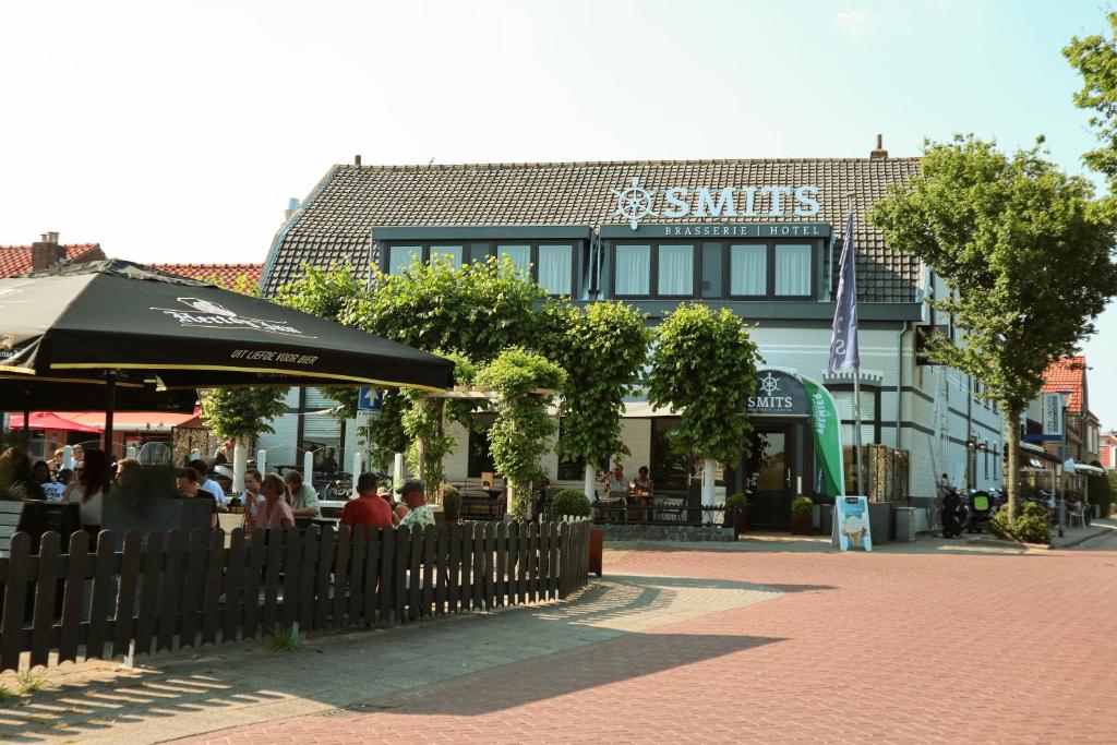 ein Restaurant mit Leuten, die vor einem Gebäude sitzen in der Unterkunft Hotel Brasserie Smits in Wemeldinge