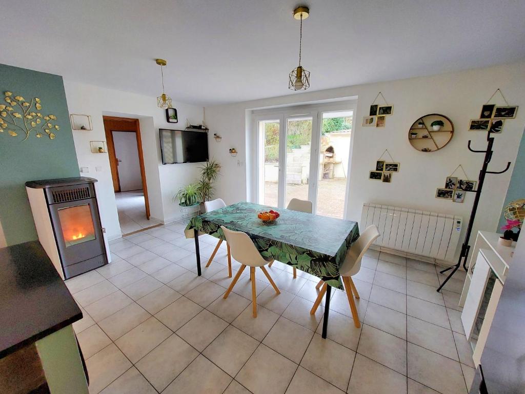 une cuisine et une salle à manger avec une table et des chaises dans l'établissement Maison spacieuse avec jardin proche Disney, à Tancrou