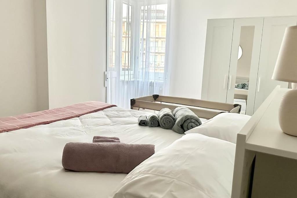 een wit bed met een handdoek erop bij Luxury apartment with view (1min from lake/center) in Como