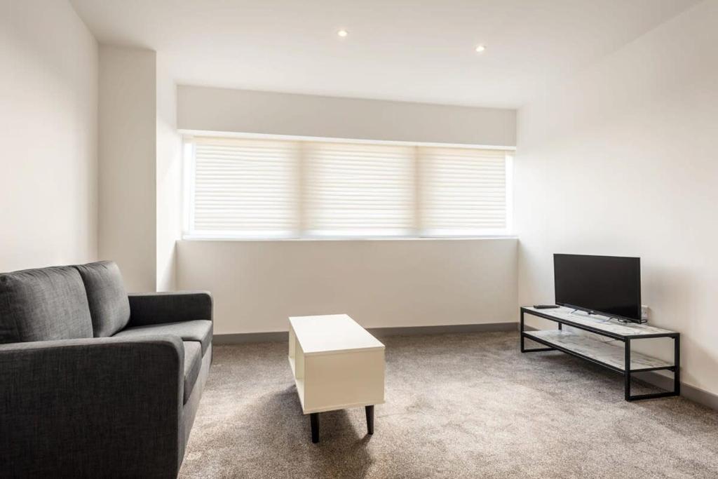 a living room with a couch and a table at Comfortable 1 Bedroom Central Doncaster Apartment in Doncaster