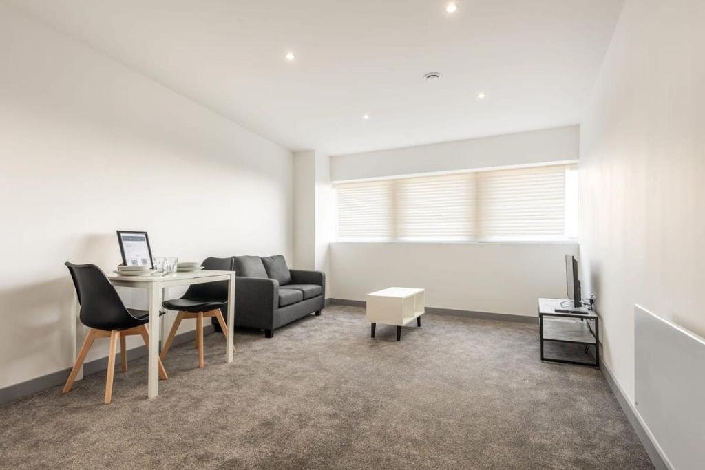 ein Wohnzimmer mit einem Tisch und einem Sofa in der Unterkunft Lovely 1 Bedroom Apartment in Central Doncaster in Doncaster