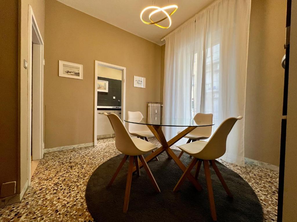 a dining room with a glass table and chairs at Bononia Host - Beverara in Bologna