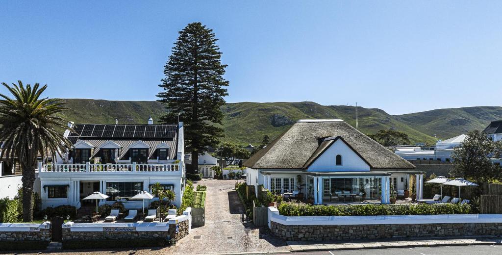 a large white building with a tree in front of it at La Fontaine Guest House Hermanus in Hermanus