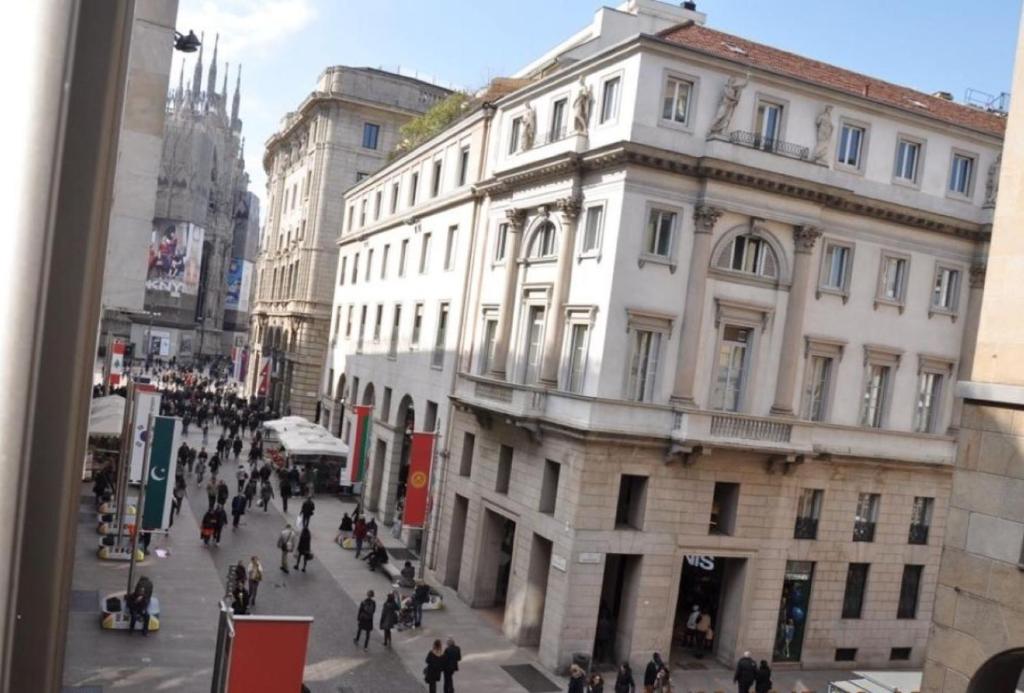 eine Gruppe von Menschen, die auf einer Stadtstraße spazieren in der Unterkunft Duomo intero appartamento in Mailand