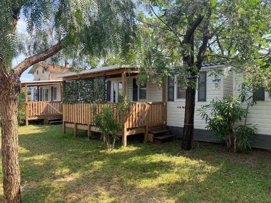 a house with a porch and a yard with trees at Mobilhomes SKALLA CZ in Martinsicuro