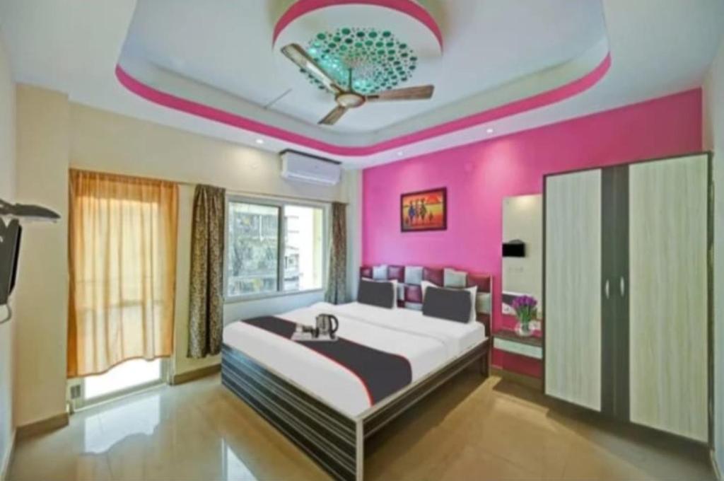 a bedroom with a large bed with pink walls at Hotel Shree Bhumi Puri - 100 Meters From Sea Beach - Best Seller in Puri