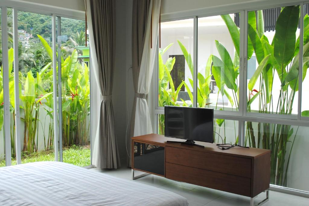 een slaapkamer met een televisie op een dressoir met een raam bij Phuket.Rent in Ban Klang