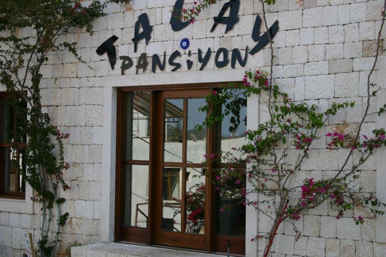 a sign on the side of a building with a window at Talay Pansiyon in Kaş